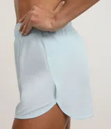 Bermuda deportiva Get Over modelo runner color beige, con cintura elástica, bajo redondeado y aberturas laterales. Cuenta con un pequeño bolsillo funcional trasero.