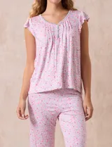 Conjunto de pijama marca René Rofé, compuesto por una remera de escote en V con botones y un pantalón capri con cintura elastizada, ambos en tejido soft estampado con motivos florales en tonos celeste y blanco.