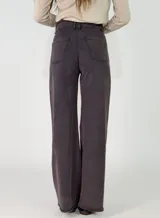 Pantalon de corte recto y tiro medio, confeccionado en gabardina color marrón. Presenta cierre frontal con botón y bolsillos laterales.