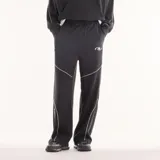Pantalón de jogging New Balance Trackside negro de corte recto y holgado, con cintura elástica con cordón ajustable, bolsillos laterales y líneas de ribete blancas en contraste. Cuenta con un pequeño logo bordado en la pierna.