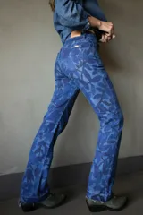Pantalón de jean de corte recto con estampado de hojas en tonos azules.