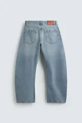 Jeans de denim de algodón en color negro con efecto lavado, corte amplio y silueta curva tipo barrel fit con pinzas en las rodillas. Presenta diseño clásico de cinco bolsillos y cierre frontal con cremallera y botón metálico.