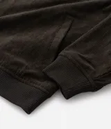 Campera bomber masculina de terciopelo cotelé color beige, con cuello redondo, mangas largas, cierre frontal de botones forrados, bolsillos laterales y terminaciones de elástico en puños y cintura.