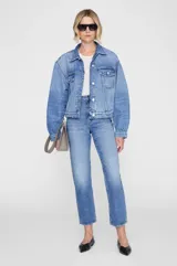 Campera de denim de corte oversize color azul, con cierre frontal de botones metálicos, bolsillos con solapa en el pecho y bolsillos laterales, confeccionada en algodón regenerativo.