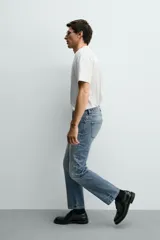Jeans regular fit de denim de algodón en color gris con efecto lavado, tiro medio, diseño de cinco bolsillos y cierre frontal con botones.