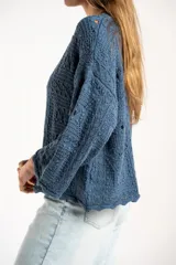Sweater de tejido de punto calado color marrón, con diseño oversize, cuello redondo y mangas tres cuartos.
