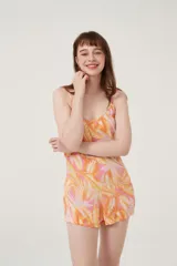 Mono corto con estampado de hojas en tonos naranja y rosa, sin mangas y con cuello redondo.