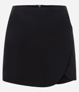 Short pollera corto de sastrería, marca Blue Steel, con diseño cruzado de traspase redondeado y cierre con cremallera en la espalda.