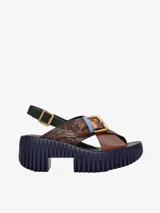 Sandalias de cuero con plataforma, tiras cruzadas y hebilla metálica.