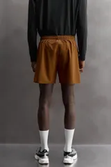 Short deportivo de entrenamiento en tejido técnico ligero y elástico, con cintura elástica ajustable mediante cordón. Presenta bolsillos frontales, un bolsillo trasero con cierre y aberturas laterales en el bajo. Incluye un pequeño logo estampado en la pernera.