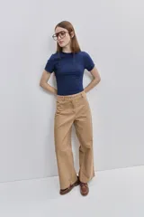 Pantalón wide leg de color tostado, con tiro medio, bolsillos laterales y cierre frontal con botón y cremallera.