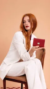 Billetera corta de símil cuero color beige, con cierre a presión y placa metálica decorativa. Cuenta con múltiples compartimentos internos para tarjetas, visor y billetes, además de un compartimento posterior con cierre.