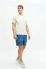 Short de baño de largo medio con estampado de hojas en tonos azules, cintura elástica con cordón ajustable, bolsillos laterales y bolsillo trasero.