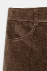Shorts mini de tiro medio confeccionados en tejido con efecto ante. Presentan trabillas en la cintura, bolsillos delanteros y cierre frontal con cremallera y botón.
