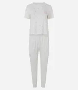 Pijama largo de dos piezas Lov, confeccionado en tejido peach touch con poliéster y elastano. Compuesto por remera de cuello redondo, manga corta con pequeño estampado floral y texto frontal, y pantalón tipo jogger con cintura elastizada y puños en los tobillos, con el mismo diseño estampado.