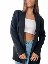 Blazer negro de corte recto y largo, con solapas y cierre frontal con dos botones blancos.