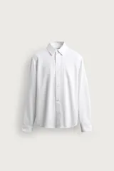 Camisa de corte regular fit en color blanco, confeccionada en mezcla de lyocell y algodón, con cuello camisero, manga larga con puño abotonado y un bolsillo aplicado en el pecho.