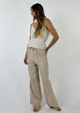 Pantalón largo de lino a rayas verticales en tonos beige, rosa y gris, con cintura alta y corte recto.