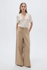 Pantalón jean verde militar, de tiro alto, corte ancho tipo wide leg y diseño de perneras amplias con costuras verticales decorativas.