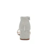 Sandalia de fiesta con taco cuadrado bajo, confeccionada en material plateado con acabado brillante. Presenta una tira frontal ancha y una pulsera al tobillo, ambas completamente cubiertas de strass.