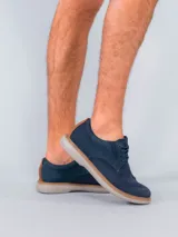 Zapato casual Hush Puppies modelo Bangu, con diseño híbrido que combina cuero en el talón y laterales con tejido técnico transpirable en la puntera y empeine. Cuenta con cordones, suela de EVA flexible y detalle de costura perimetral en tono natural.