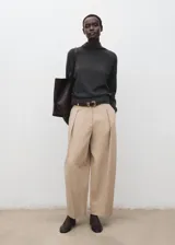 Jersey de punto gris oscuro con cuello alto y mangas largas, de diseño clásico y cómodo.