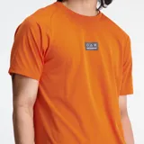 Remera deportiva naranja de manga corta con logo de New Balance en el pecho.