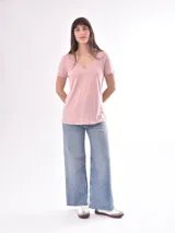 Remera blanca de manga corta con escote en V, de tejido ligero y ligeramente traslúcido.