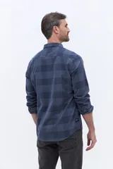 Camisa de manga larga confeccionada en viyela de algodón con diseño a cuadros en tonos verde oscuro. Presenta cuello clásico, cierre frontal con botones y bolsillo aplicado en el pecho.