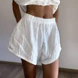 Conjunto de dos piezas compuesto por un top de tirantes con hombros caídos y un short con cintura elástica, confeccionado en tejido de punto con textura acanalada.
