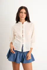 Camisa de algodón bordado color crudo, con cuello mao, manga 3/4 y cierre frontal con broches de estilo oriental.
