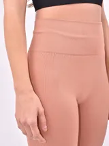 Calza larga de lycra color rosa viejo, con cintura alta y corte ajustado.