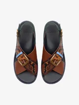 Sandalias de cuero con plataforma, tiras cruzadas y hebilla metálica.