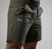 Short deportivo de poliamida y elastano en color verde militar, con cintura elástica ajustable mediante cordón, bolsillos laterales y logo bordado en contraste en la pierna derecha.