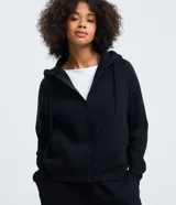 Buzo negro con capucha ajustable mediante cordones, cierre frontal de cremallera y bolsillos laterales. Presenta puños y bajo acanalados, confeccionado en tejido de algodón con felpa.