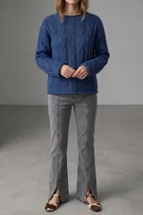 Sweater de tejido de punto con diseño de trenzas verticales, cuello redondo y mangas largas.