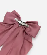 Pinza para el pelo con un gran lazo de tela satinada, que presenta dos largas colas caídas. El color es un tono rosado apagado o malva.