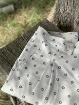 Pantalón de campo color crudo con estampado de pequeñas flores azules, de lino artesanal.