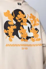 Buzo tipo canguro color negro con capucha y cordones ajustables. Presenta un pequeño estampado en el pecho con la silueta de Mickey Mouse y un detalle a cuadros en color verde.