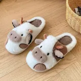 Pantuflas de peluche con diseño de vaca, confeccionadas en piel sintética suave. Cuentan con suela de goma antideslizante y diseño abierto en el talón.