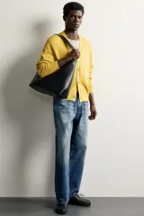 Bolso tipo shopper color negro con diseño liso, asa de hombro y compartimento principal con cierre de cremallera.