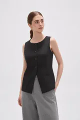Chaleco sin mangas de corte sastrero, color marrón con diseño de rayas verticales finas. Presenta cuello redondo, cierre frontal con botones y dos bolsillos laterales simulados.