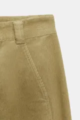 Pantalón de tiro alto confeccionado en pana, con diseño de pernera holgada que se estrecha hacia el tobillo. Presenta bolsillos delanteros, bolsillos de plastrón en la parte trasera, costuras marcadas en el frente y cierre frontal con cremallera y botón.