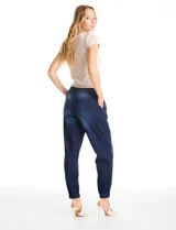 Pantalón tipo jogger de denim azul con efecto lavado. Presenta cintura elástica con cordón ajustable, bolsillos laterales y traseros, y puños elásticos en los tobillos.
