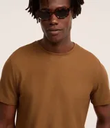 Remera de hombre color beige, de corte regular, cuello redondo y manga corta.