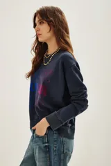 Buzo de cuello redondo y manga larga, en color azul oscuro con efecto lavado. Presenta un estampado frontal con la palabra 'HAPPY' repetida en un degradado de colores vibrantes.