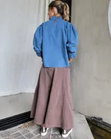 Pollera larga de denim color celeste claro, con corte en A y talle alto con elástico en la cintura.