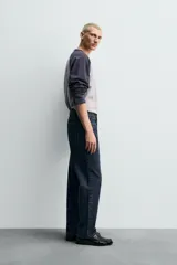 Camiseta de corte relajado con diseño color block, cuerpo en gris melange y mangas largas raglán en color azul marino. Presenta cuello redondo al tono de las mangas y bajo con acabado irregular.