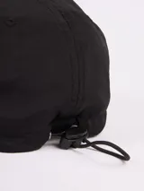 Gorro con visera Rusty de nylon color negro, con parche bordado frontal y cordón elástico en la parte posterior.