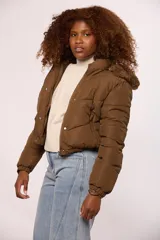 Campera bomber de nylon color rosado, con diseño acolchado, cierre frontal con cremallera y botones a presión, y capucha con borde de piel sintética al tono.